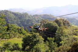 A guest rides with both arms out on the 3,280 foot long superman cable on April 17, 2013.